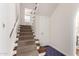 Staircase with carpet runner and wood railing leading to upper level, adjacent to tiled floor at 374 E Verde Ln, Phoenix, AZ 85012