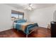 Bedroom with wood floors, ceiling fan, and natural light from a large window at 3875 E Juanita Ave, Gilbert, AZ 85234