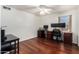 Bedroom with wood floors, a ceiling fan, a window, and two dark wooden desks to be used as office space at 3875 E Juanita Ave, Gilbert, AZ 85234