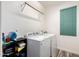 Bright laundry room featuring a washer and dryer, complemented by shelves for storage and a window at 3875 E Juanita Ave, Gilbert, AZ 85234