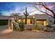 Stylish desert home featuring an arched entryway, mature cacti, and inviting outdoor lighting at 39912 N 98Th Way, Scottsdale, AZ 85262