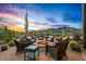 Inviting firepit area with cushioned seating offers stunning sunset views in this desert oasis at 39912 N 98Th Way, Scottsdale, AZ 85262