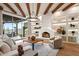 Bright living room with fireplace, custom shelves, and large sliding door to patio at 39912 N 98Th Way, Scottsdale, AZ 85262