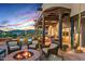 Relaxing outdoor space with covered patio, fire pit, lounge chairs, and desert landscape with mountain views at 39912 N 98Th Way, Scottsdale, AZ 85262
