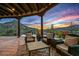 Covered outdoor patio area featuring comfortable seating, desert views, and seamless indoor/outdoor living at 39912 N 98Th Way, Scottsdale, AZ 85262