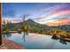 Resort-style infinity pool blending seamlessly with desert landscape and a picturesque sunset mountain view at 39912 N 98Th Way, Scottsdale, AZ 85262