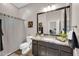 Bathroom showcasing a shower with a striped curtain, vanity with granite counters, and modern fixtures at 4013 N Founder Cir, Buckeye, AZ 85396