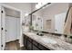 Bathroom features a double sink vanity with granite countertops, dark cabinetry, and a framed mirror at 4013 N Founder Cir, Buckeye, AZ 85396