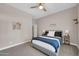 Calm bedroom with a blue and white striped blanket on the bed, carpet flooring, and a ceiling fan at 4013 N Founder Cir, Buckeye, AZ 85396