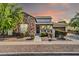 Charming single-Gathering home with stone accents, a cozy porch, and manicured landscaping at sunset at 4013 N Founder Cir, Buckeye, AZ 85396