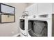 Well-organized laundry room with modern, front-load washer and dryer units, and ample storage at 4013 N Founder Cir, Buckeye, AZ 85396