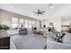Bright living room with a sectional sofa, a ceiling fan and tons of natural light at 4013 N Founder Cir, Buckeye, AZ 85396