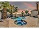 Outdoor pool and spa combination featuring lush tropical landscaping for a relaxing backyard oasis at 4013 N Founder Cir, Buckeye, AZ 85396