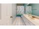 Well-lit bathroom with white vanity, ample storage, and a tub with a stylish curtain at 4014 W Anderson Dr, Glendale, AZ 85308