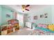 A cozy bedroom with a dollhouse, complemented by vibrant artwork and a colorful bedspread at 4014 W Anderson Dr, Glendale, AZ 85308