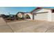 Well-maintained home exterior with a large driveway and attractive landscaping at 4014 W Anderson Dr, Glendale, AZ 85308