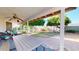 A relaxing covered patio with a ceiling fan, overlooks a backyard featuring mature trees, offering an inviting outdoor retreat at 4014 W Anderson Dr, Glendale, AZ 85308