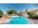 A backyard pool surrounded by lush landscaping and a white fence, offering a private and refreshing outdoor retreat at 4014 W Anderson Dr, Glendale, AZ 85308
