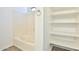 This bathroom offers a tub with a towel ring and a storage area with multiple shelves for organization at 516 N Emery --, Mesa, AZ 85207