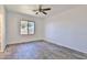 Neutral bedroom with a ceiling fan, wood-look flooring, and a bright window at 516 N Emery --, Mesa, AZ 85207