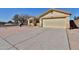 Beige single-story home featuring a two-car garage and a long driveway at 516 N Emery --, Mesa, AZ 85207