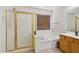 Bathroom with tile floors, shower with gold trim, soaking tub, and vanity at 5309 W Angela Dr, Glendale, AZ 85308