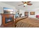 Main bedroom with hardwood floors, ceiling fan, fireplace, and flatscreen television at 5309 W Angela Dr, Glendale, AZ 85308