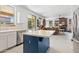 Open kitchen flows into living space, features white cabinets, stainless appliances, blue island, and bright light at 5309 W Angela Dr, Glendale, AZ 85308