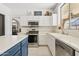 Close-up of kitchen features: white cabinets, countertops, stainless appliances, tile floor, and natural light at 5309 W Angela Dr, Glendale, AZ 85308