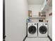 Functional laundry room with front-load washer and dryer, storage shelves, and ample space for sorting and folding at 5309 W Angela Dr, Glendale, AZ 85308