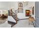 Elegant foyer features a staircase with wrought iron railing and wood banister, complemented by neutral tile flooring at 5309 W Angela Dr, Glendale, AZ 85308