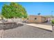 Spacious backyard with gravel, mature trees, and covered patio seating area at 5402 E Mckellips Rd # 298, Mesa, AZ 85215