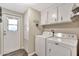 Convenient laundry room with washer, dryer, storage cabinets, and backyard access at 5402 E Mckellips Rd # 298, Mesa, AZ 85215
