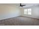 Spacious bedroom featuring plush carpet, bright windows, and a modern ceiling fan at 5430 S 23Rd Way, Phoenix, AZ 85040