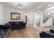 Bright living room with a plush gray sofa, wood-look floors, and white walls at 5430 S 23Rd Way, Phoenix, AZ 85040