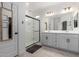 A sleek bathroom with double sinks, a large mirror, a walk-in shower, and modern fixtures at 5712 S Parkwood --, Mesa, AZ 85212
