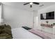 Bright bedroom features a ceiling fan, plush carpet, and a TV mounted above a decorative table at 5712 S Parkwood --, Mesa, AZ 85212
