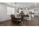 Open dining area with stylish lighting, a long wooden table, and seating for eight at 5712 S Parkwood --, Mesa, AZ 85212