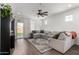 Bright living room with large sectional, wood floors, and a sliding glass door at 5712 S Parkwood --, Mesa, AZ 85212