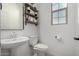 This stylish powder room features pedestal sink, decorative shelves, and a frosted glass window at 5712 S Parkwood --, Mesa, AZ 85212
