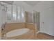 Bathroom featuring a soaking tub with a hand shower and a glass enclosed walk-in shower with tile surround at 6071 S Topaz Pl, Chandler, AZ 85249