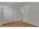 This bedroom features wood flooring, a ceiling fan, a closet, and a white door to another room at 6071 S Topaz Pl, Chandler, AZ 85249