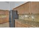 Spacious kitchen featuring stainless steel appliances, granite countertops, tile backsplash, and wooden cabinetry at 6071 S Topaz Pl, Chandler, AZ 85249
