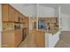 Bright kitchen featuring an island, granite countertops, tile backsplash, wooden cabinetry, and stainless steel appliances at 6071 S Topaz Pl, Chandler, AZ 85249