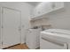 A well lit laundry room featuring a washer and dryer and ample storage space, plus a service door at 6071 S Topaz Pl, Chandler, AZ 85249