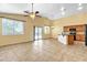 Open-concept living room area with tile floors, a ceiling fan, and a kitchen with modern appliances and backyard access at 6071 S Topaz Pl, Chandler, AZ 85249