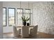 Bright dining room with stylish table, chairs, stone accent wall, and modern lighting fixtures at 6147 E Desert Cove Ave, Scottsdale, AZ 85254