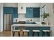 Modern kitchen with blue cabinets, stainless steel appliances, and a white countertop island at 6147 E Desert Cove Ave, Scottsdale, AZ 85254