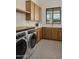 Contemporary laundry room featuring modern appliances, abundant cabinets, and stylish flooring at 6147 E Desert Cove Ave, Scottsdale, AZ 85254