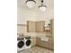 Beautiful laundry room featuring a farmhouse sink, modern appliances, and plenty of storage at 6147 E Desert Cove Ave, Scottsdale, AZ 85254